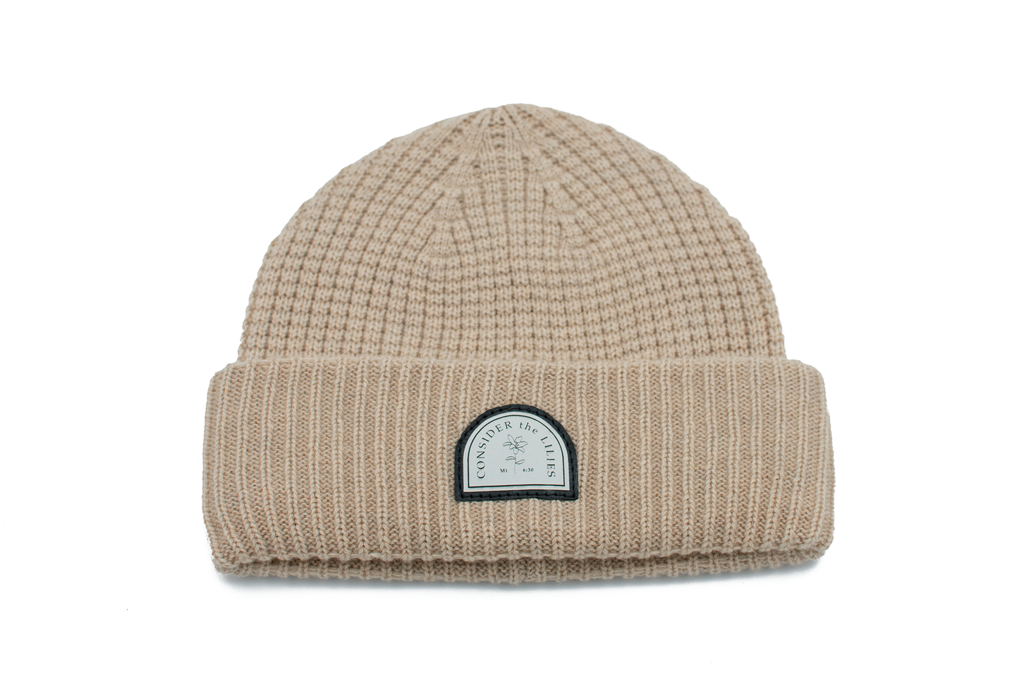 Beige knit beanie with a logo patch on a white background